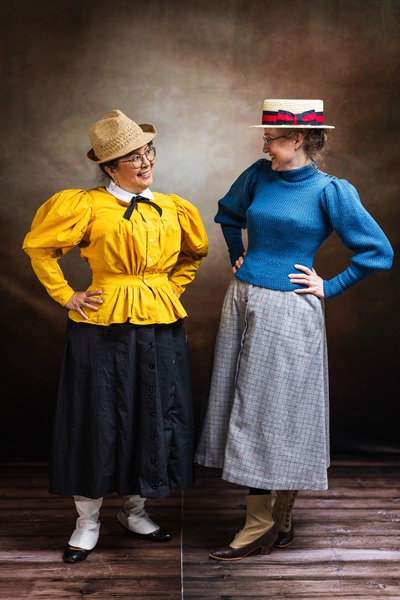 Reproduction 1890s Yellow Cycling on left and friend at Costume College 2025. Photo by Mark Edwards Photographer. Truly Victorian TV494 Shirtwaist. Truly Victorian TV299 Split Skirt. Laughing Moon B7 Gaiters. 